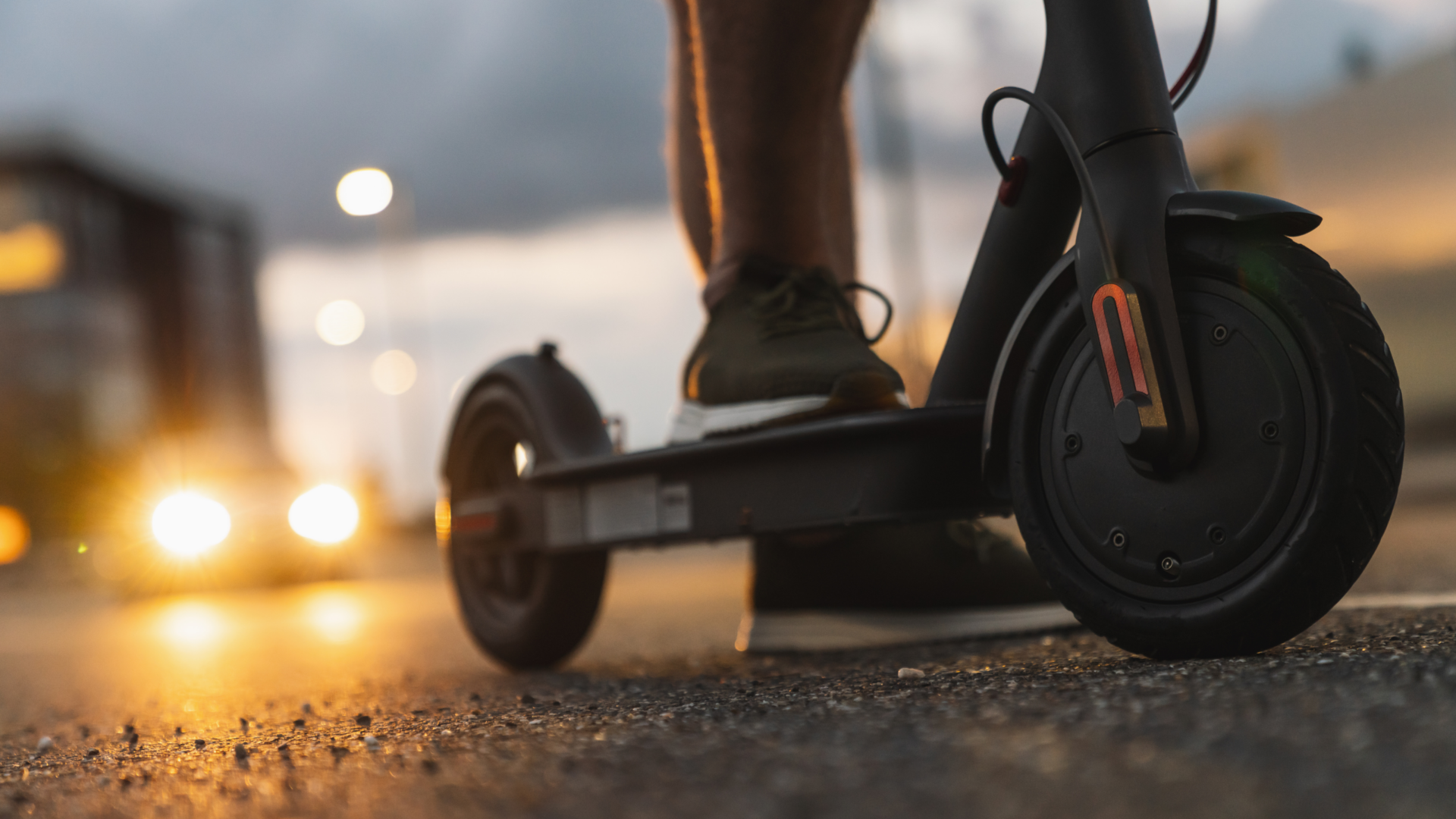 close up of a scooter's wheels with someone standing on it