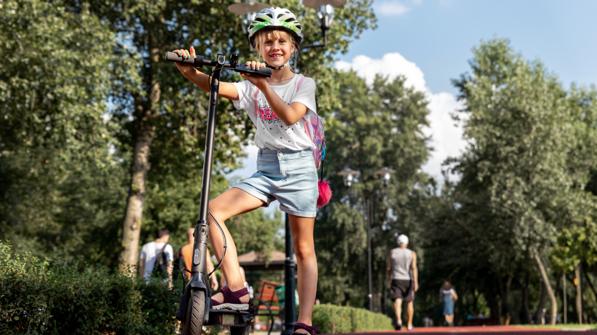 Young girl riding on a kid-friendly electric scooter.