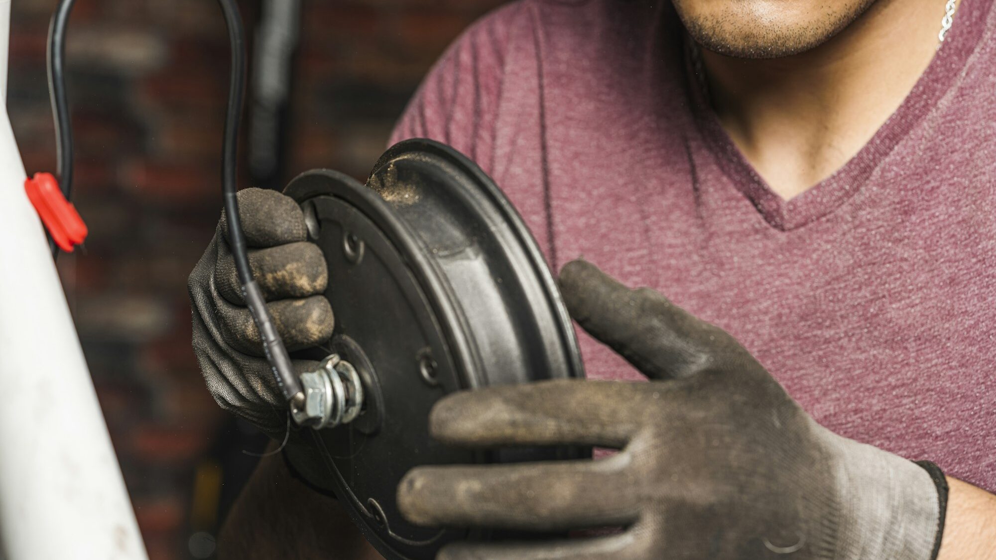 A mechanic holding a wheel rim of an electric scotter for repair