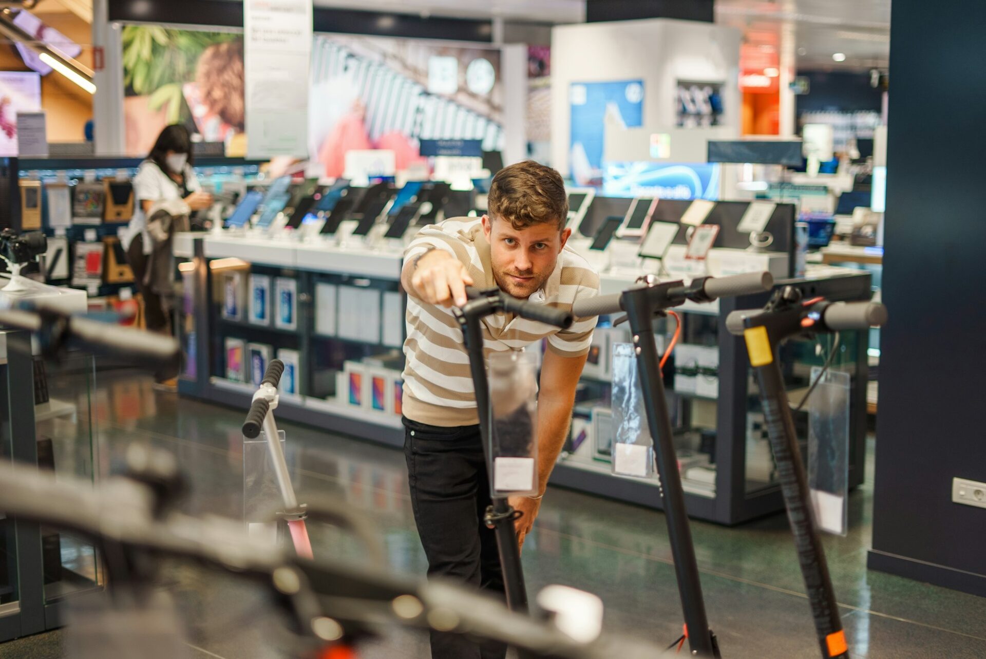 Man choosing electric scooter in store