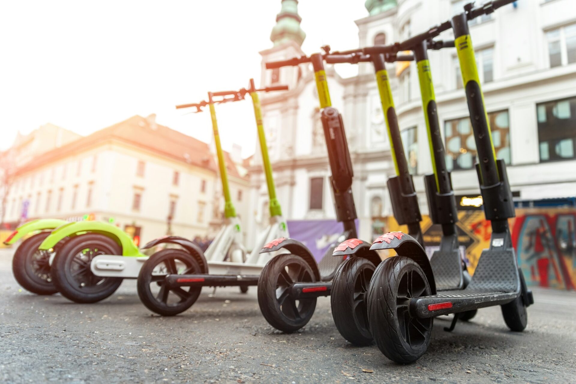 Many modern electric kick scooters sharing parked on city street. Self-service street transport rent