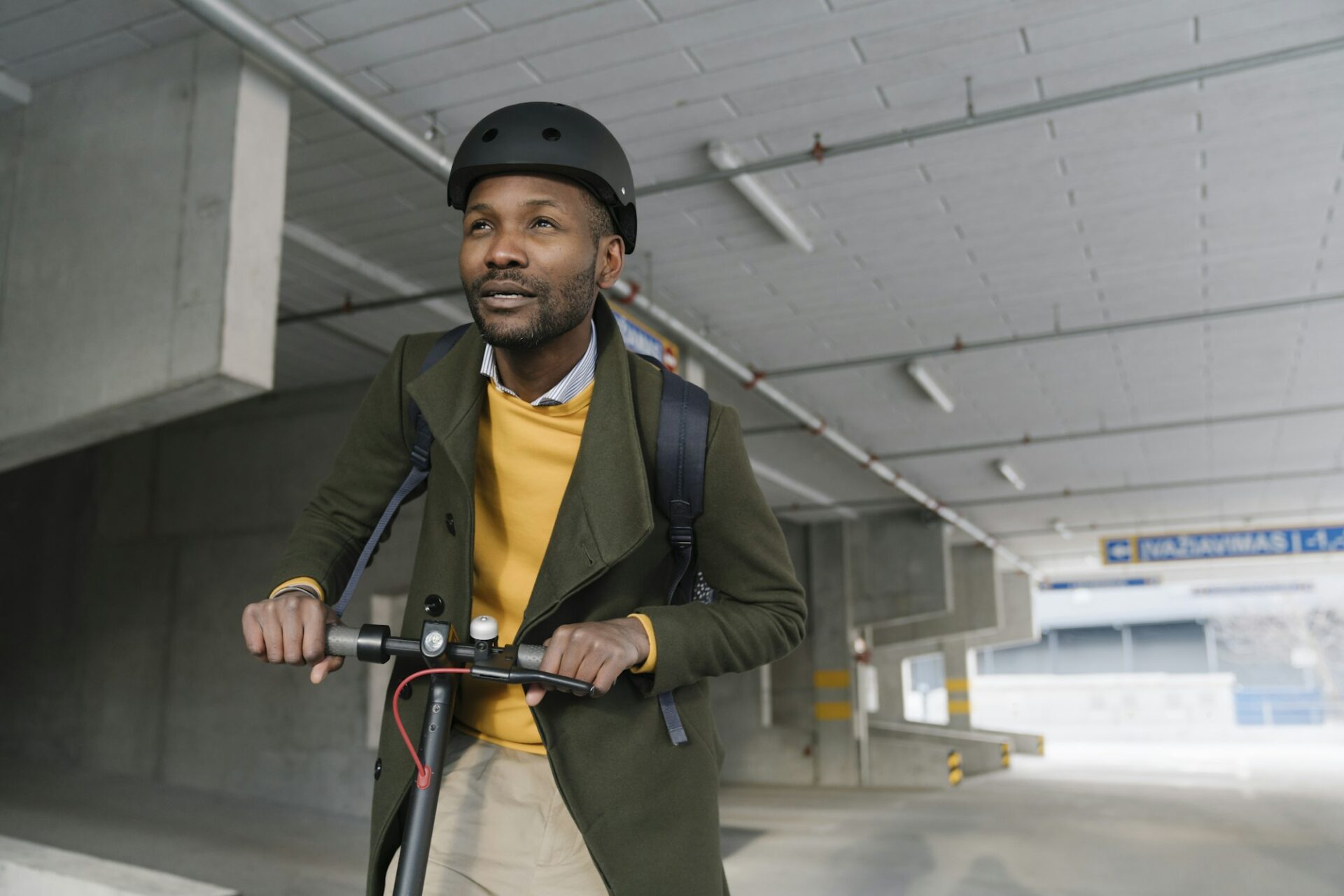 Portrait of stylish man with helmet and scooter in the city