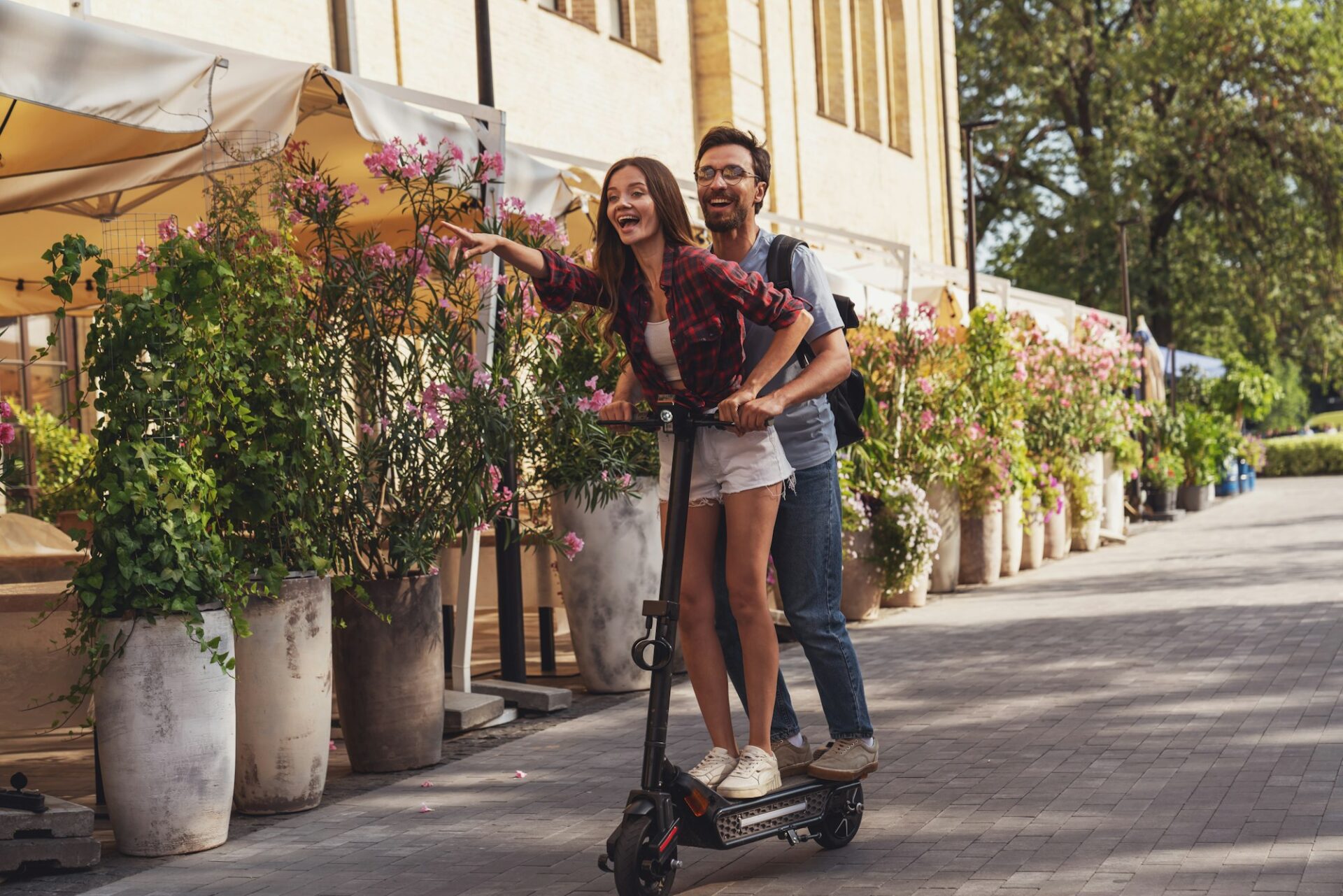 Happy couple riding on an electric scooter.